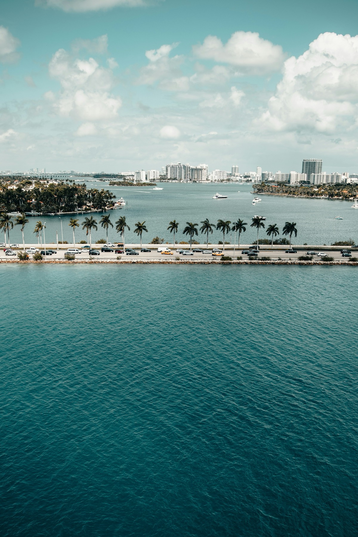 Aerial view of Miami's bay, palm-lined causeway and skyline by day